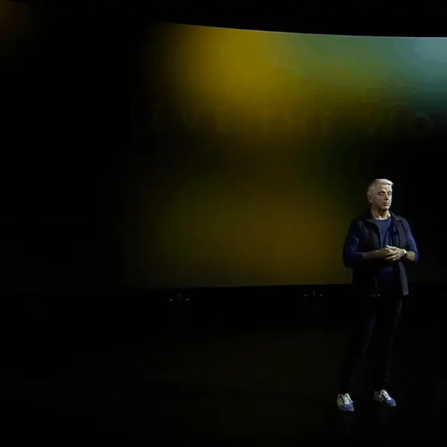 A presenter on the Unite 2022 keynote stage below large on-screen text.